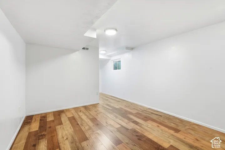 Interior room featuring neutral white wall finishes, wood-finish flooring, and recessed ceiling lighting