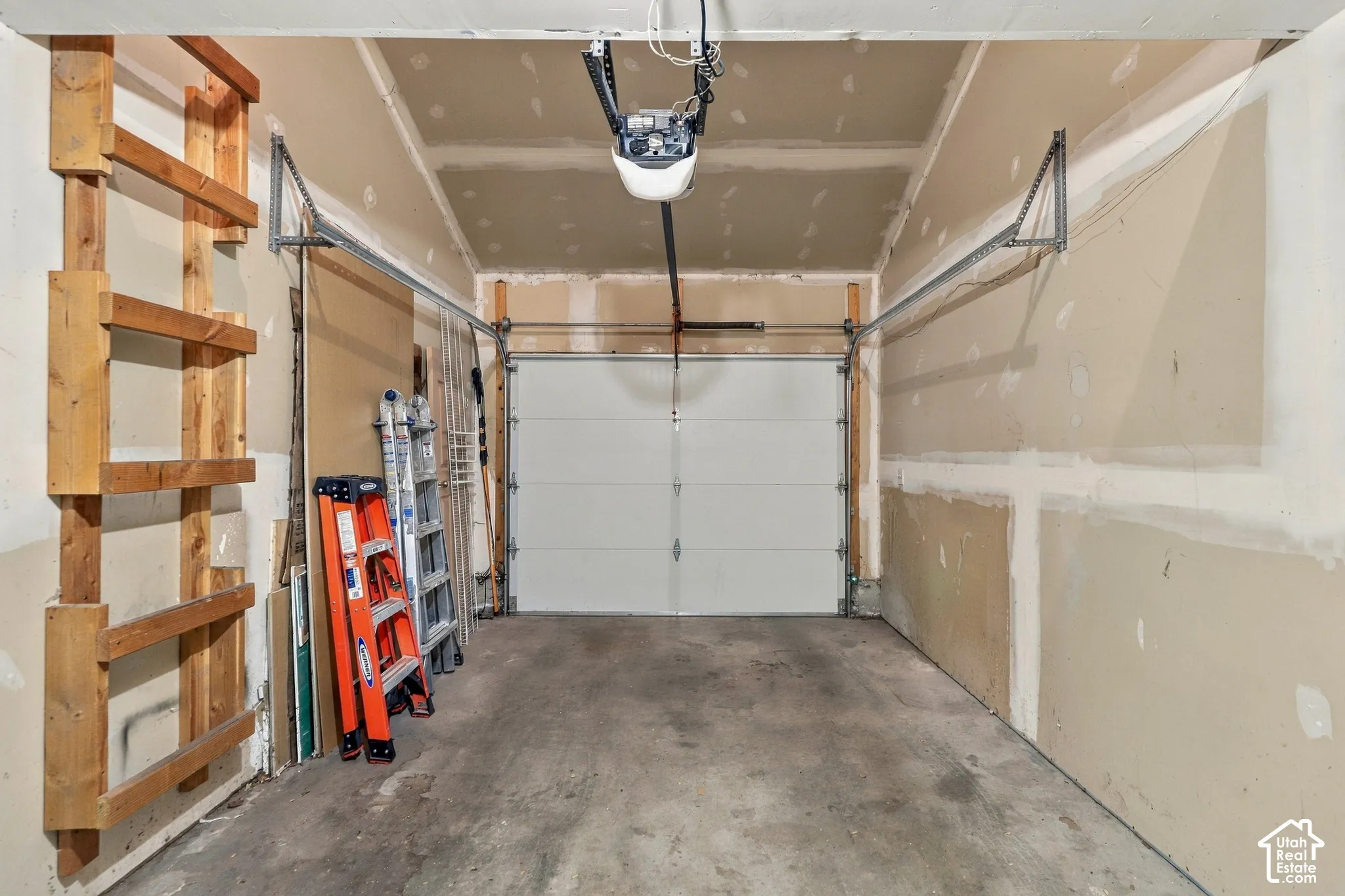 Integrated garage door, automatic garage door opener, concrete flooring, built-in wooden shelving