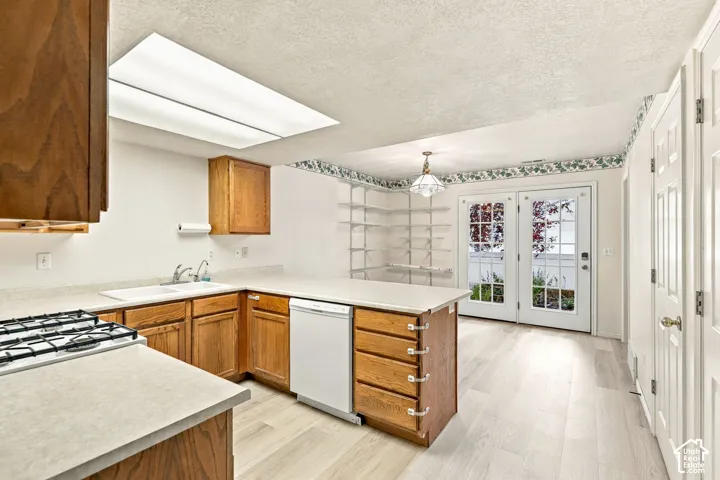 Spacious kitchen featuring warm wood cabinetry, stainless steel appliances, and tile backsplash