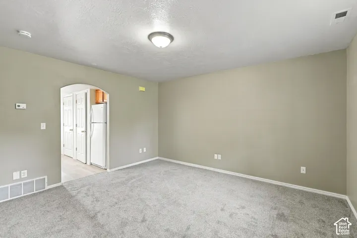 Spacious bedroom with neutral wall finishes, recessed ceiling lighting, and carpet flooring