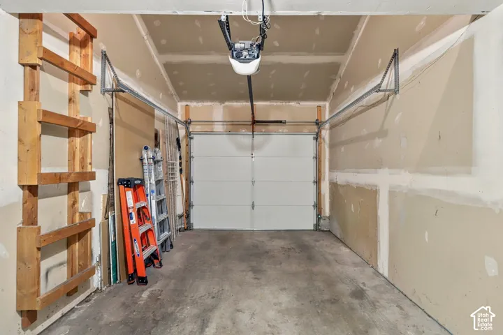 Integrated garage door, automatic garage door opener, concrete flooring, built-in wooden shelving