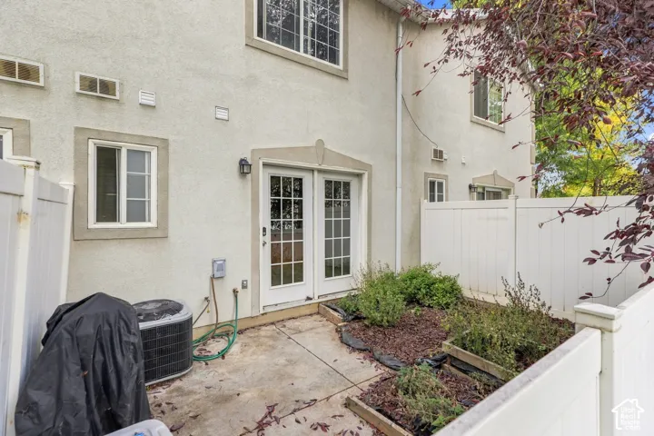 Private patio with concrete flooring, framed by white privacy fencing