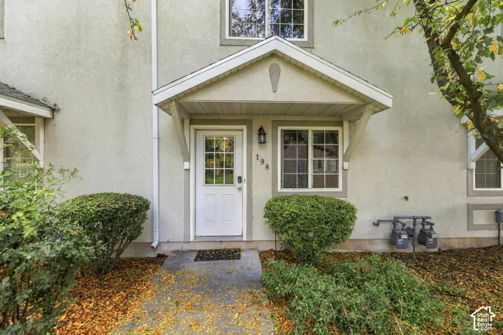 Welcoming entry features a covered front portico with peaked roofline, white paneled door with sidelights, and dual multi-pane windows