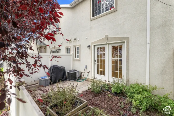 Stucco exterior with multiple windows and a white framed double door with grid patterns
