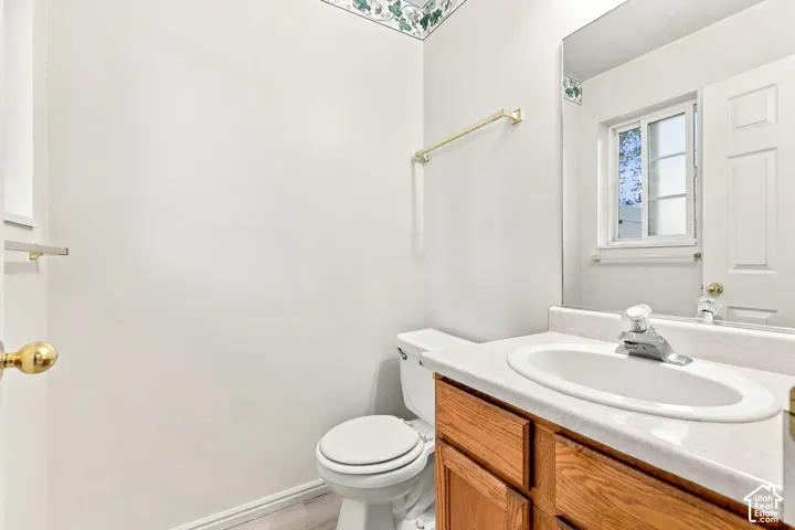 Clean and functional bathroom featuring a wood-finish vanity with dual sink basin, white countertop, and chrome hardware