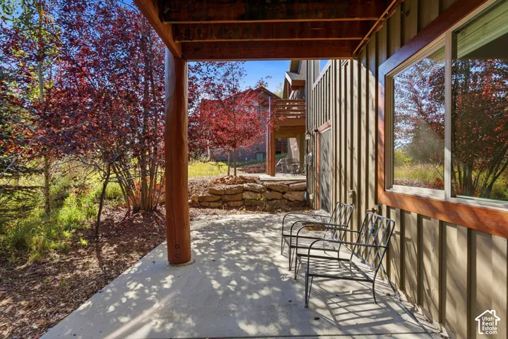 Covered outdoor patio with exposed wood structural elements and concrete flooring