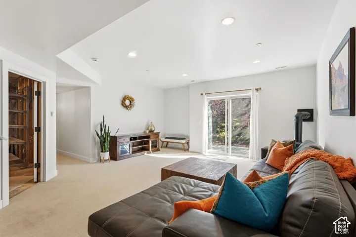 Recessed lighting, wood-finish flooring, and a built-in wood stove are featured in this expansive room with sliding glass doors