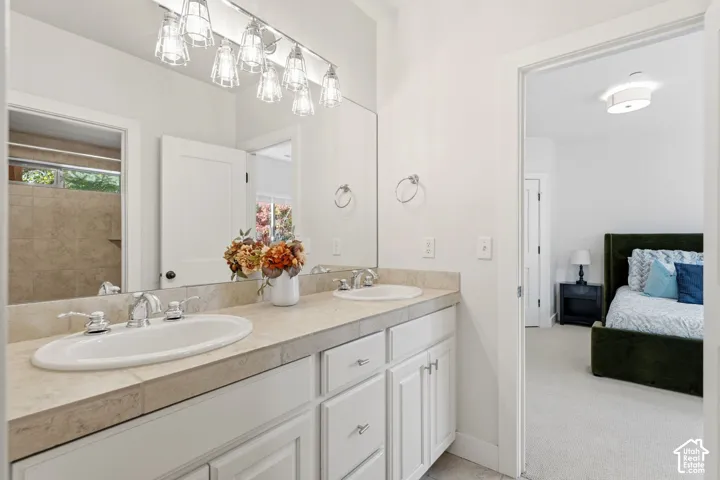 Dual undermount sinks, chrome fixtures, integrated vanity lighting, and a large wall-mounted mirror