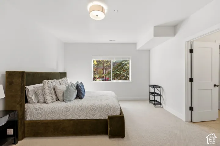 Recessed lighting fixture illuminating a bright, neutral-toned room with plush carpeting