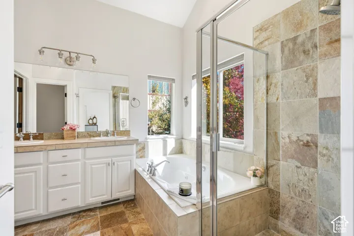 Dual vanity with undermount sinks, tile countertop, and expansive mirror