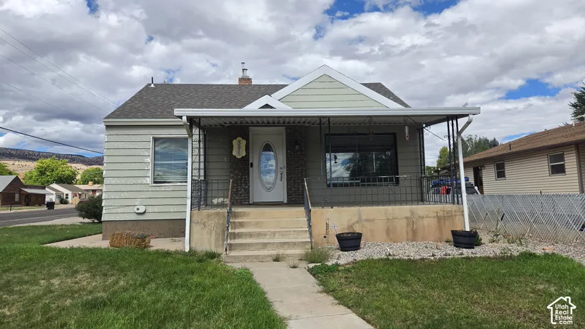 Front facade with a covered porch, concrete steps, and a white front door