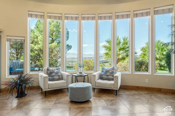 Curved wall with multiple floor-to-ceiling windows, tile flooring, and light-toned walls