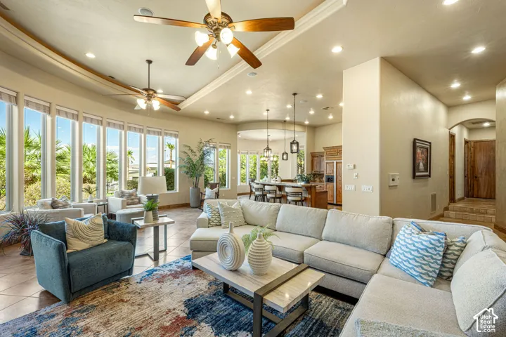 Spacious living area featuring high ceilings, recessed lighting, two ceiling fans, and large windows