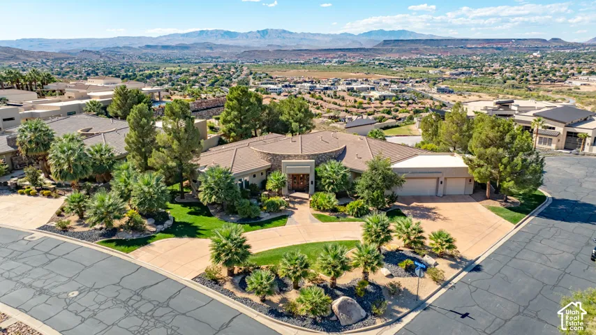 Stucco exterior with stone accents, a multi-car driveway, a two-car garage, and manicured landscaping