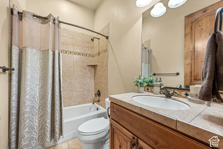 Full vanity with tile countertop, integrated sink, and bronze-finish faucet