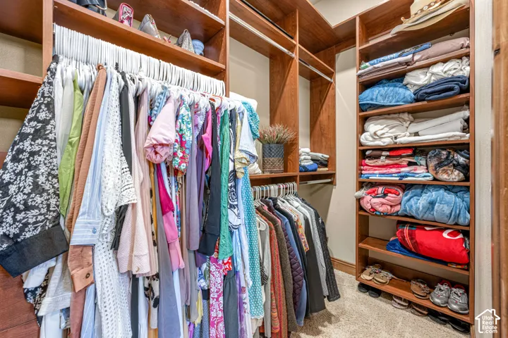 Custom closet system featuring wood-finish shelving and multiple hanging rods