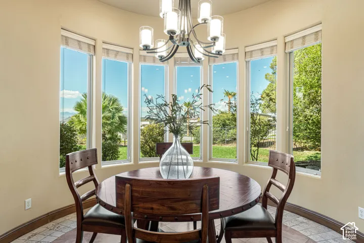 Bay window dining area featuring multiple windows, a decorative chandelier, and tile flooring