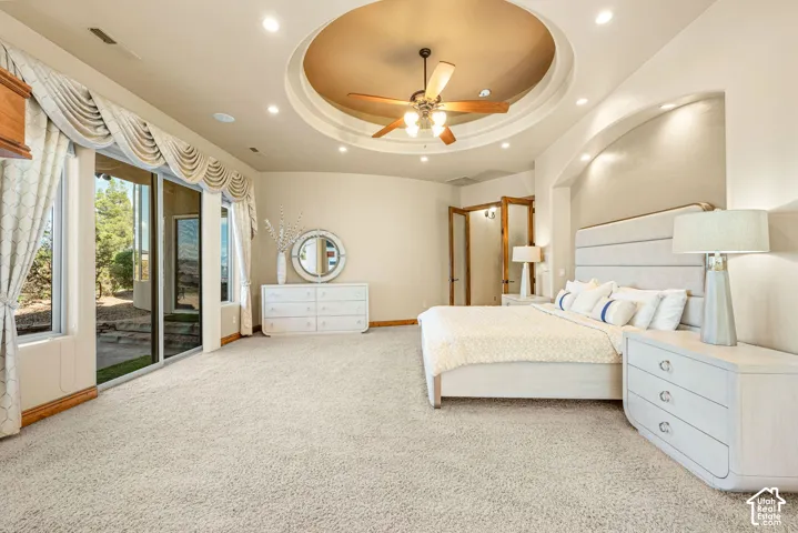 Recessed lighting and a decorative ceiling fan illuminate a tray ceiling