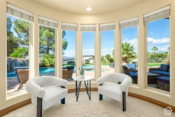 Curved wall with multiple windows, recessed lighting, and light-colored carpet flooring
