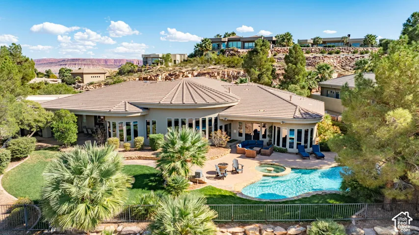 Resort-style backyard featuring a freeform swimming pool, integrated spa, and extensive paver patio