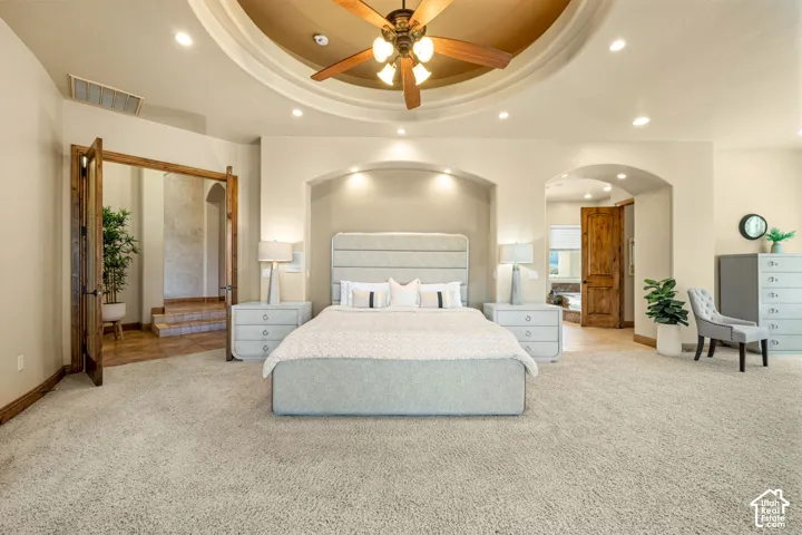 Recessed lighting, arched doorways, wood-finish flooring, wood ceiling fan, and a tray ceiling
