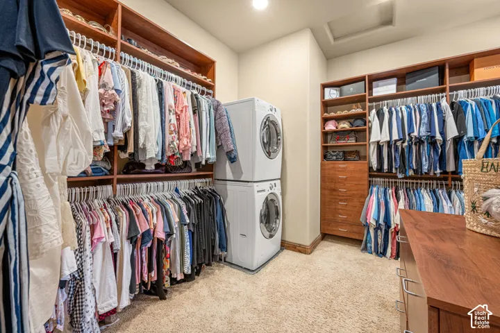 Built-in custom cabinetry, integrated shelving, and stacked laundry appliances