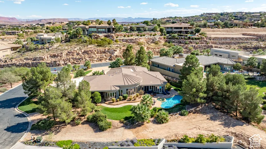 Expansive property with a curvilinear swimming pool, mature trees, and a manicured lawn