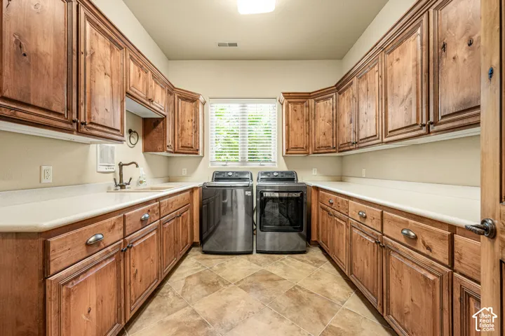 Extensive wood cabinetry, light-toned countertops, and a utility sink with a bronze-finish faucet