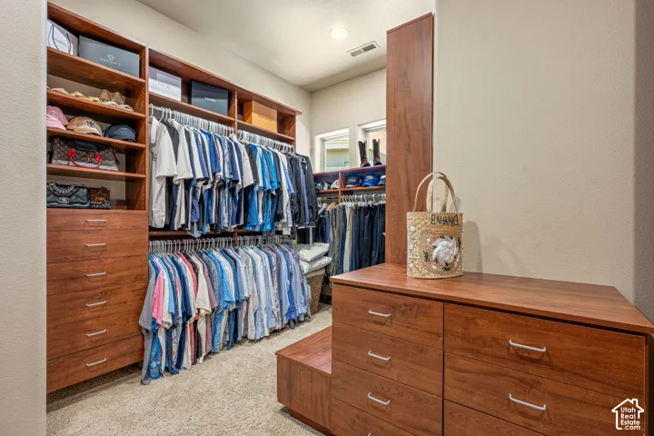Built-in wood-finish cabinetry featuring multiple drawers, shelving, and hanging rods