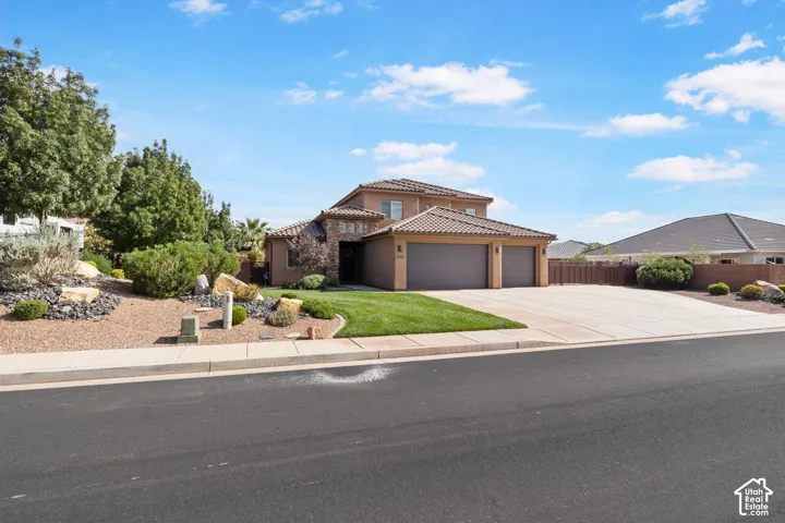 Two-story residence with a multi-car garage, concrete driveway, and a tiled roof