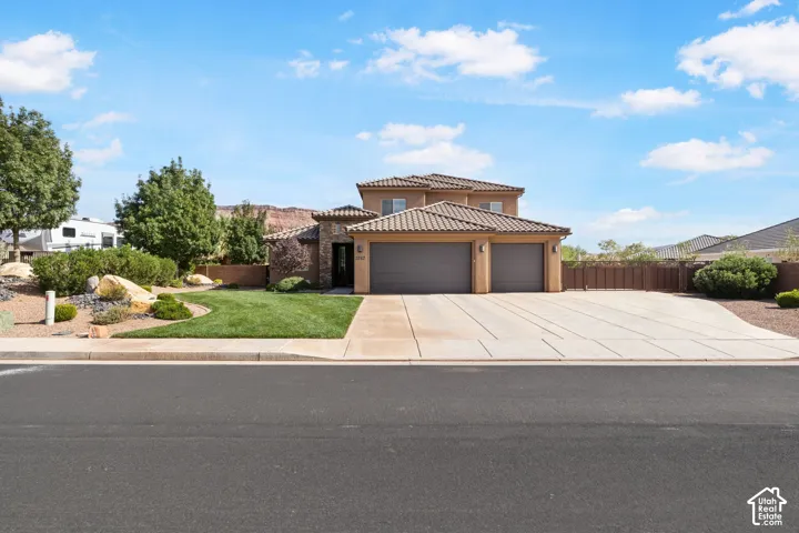 Multi-story stucco exterior with a tile roof and a two-car garage