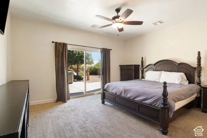 Carpeted room featuring a ceiling fan with integrated lighting and sliding glass doors to an outdoor patio