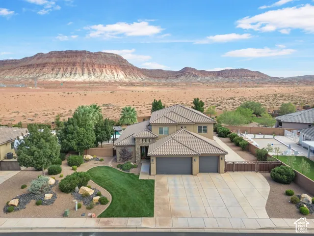 Stucco exterior with a tiled roof, a two-car garage, and a concrete driveway