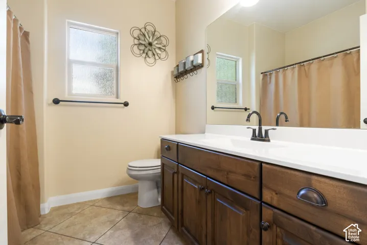 Bathroom featuring a dark wood-finish vanity with a white countertop and bronze-finish hardware