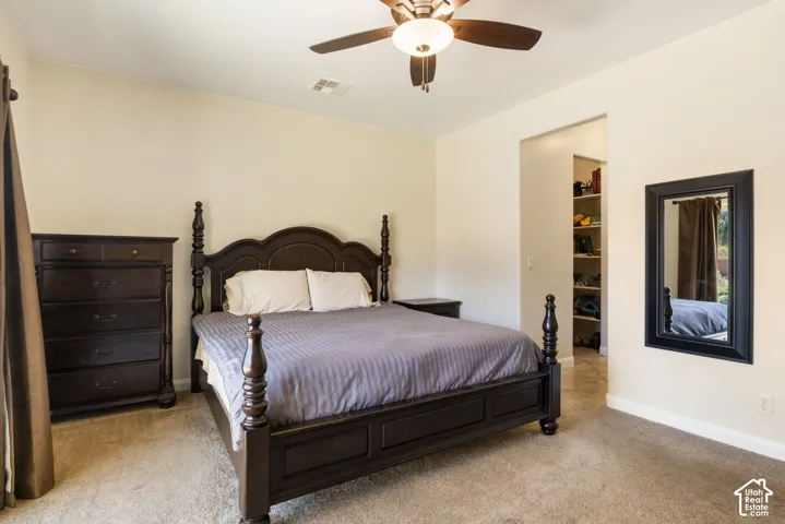 Carpeted bedroom featuring a ceiling fan with integrated lighting