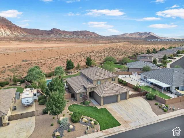 Tile roof, arid landscape, exterior swimming pool, multi-car driveway, attached garage