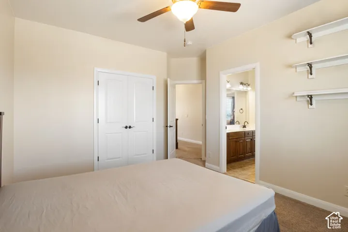 Carpeted room featuring a ceiling fan with integrated lighting, white bi-fold closet doors, and recessed shelving