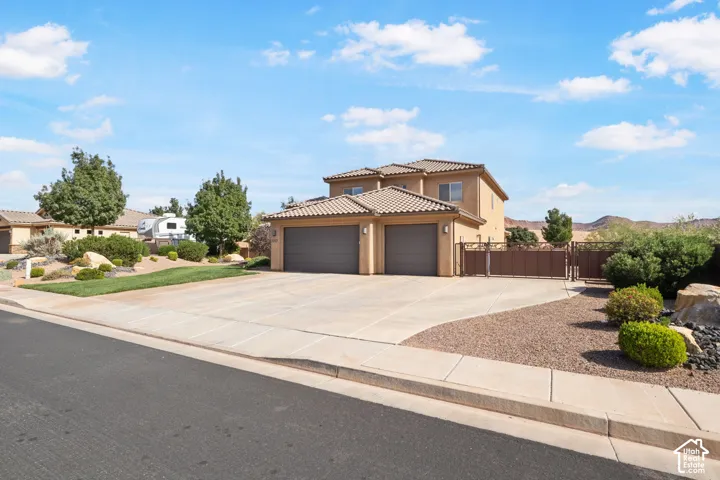 Two-story residence with a two-car garage, concrete driveway, and a gated side yard