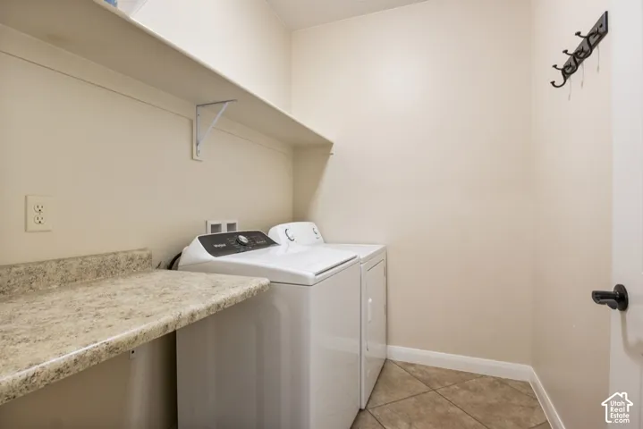 Functional utility space featuring a built-in shelf, speckled countertop, and tiled flooring