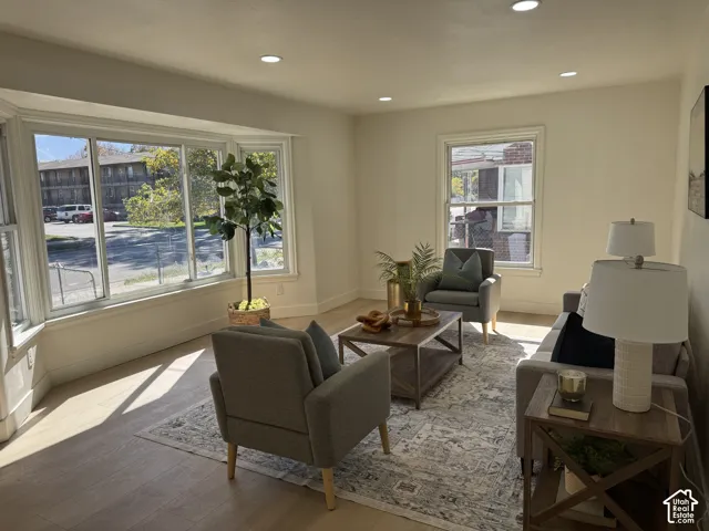 Bay window with multiple panes, wood-finish flooring, recessed ceiling lighting, and a single-pane window