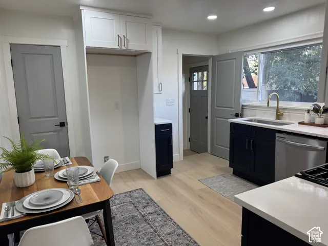 Light-toned wood-finish flooring complements the white walls and modern recessed lighting