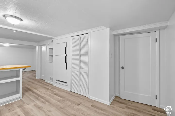 Wood-finish flooring throughout, with a built-in refrigerator, louvered bi-fold doors, and recessed lighting