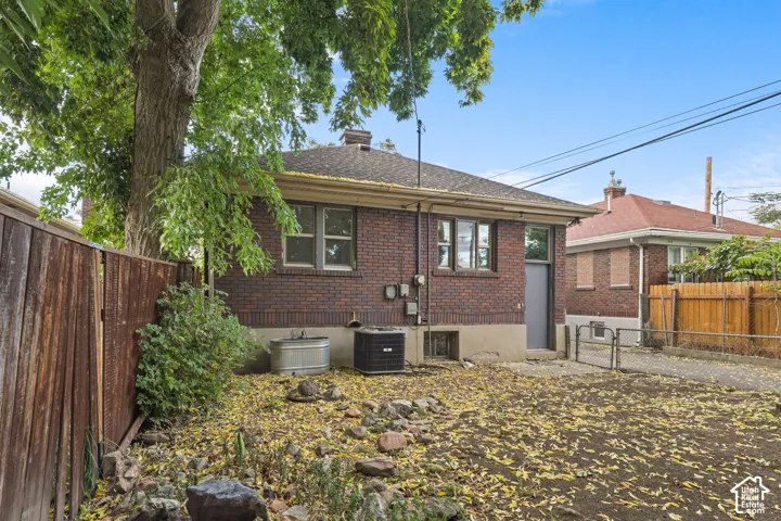 Brick exterior, mature tree, wood fencing, paved driveway, gabled roofline