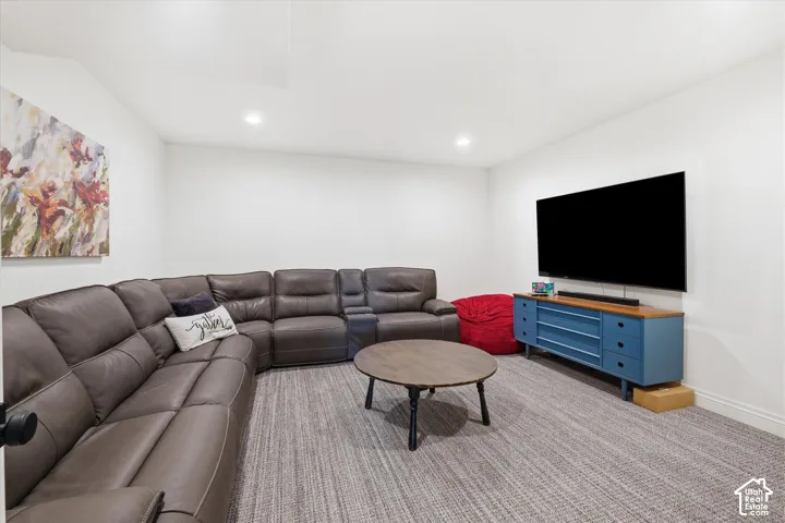 Recessed lighting illuminates a spacious room featuring wall-to-wall carpeting