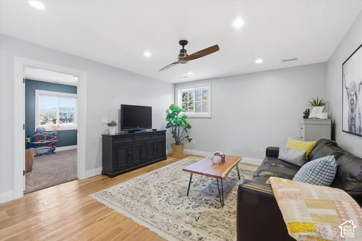 Hardwood flooring with recessed lighting, a ceiling fan, and a built-in media console