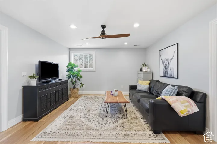 Recessed lighting, wood-finish flooring, and a ceiling fan with integrated lighting
