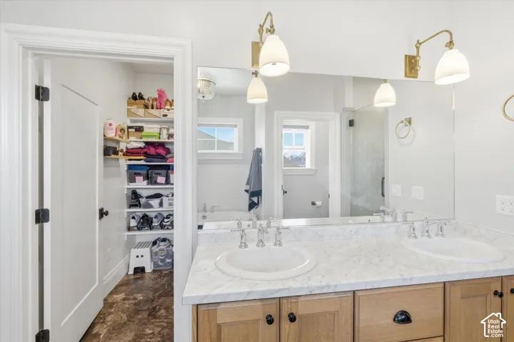 Dual vanity with undermount sinks, light wood-finish cabinetry, and a large wall-mounted mirror