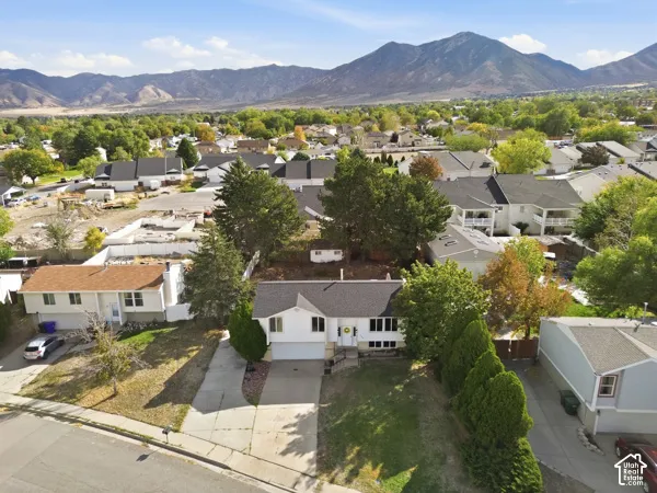 Mountain backdrop, neighborhood setting, mature trees, residential street, paved driveway