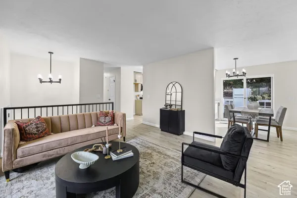 Light wood-finish flooring throughout, featuring a dining area with a modern chandelier and large windows