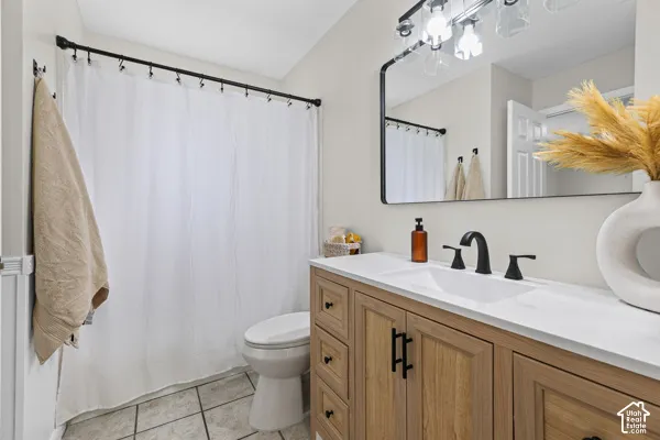 Wood-finish vanity with black hardware, integrated white sink, and matte black faucet
